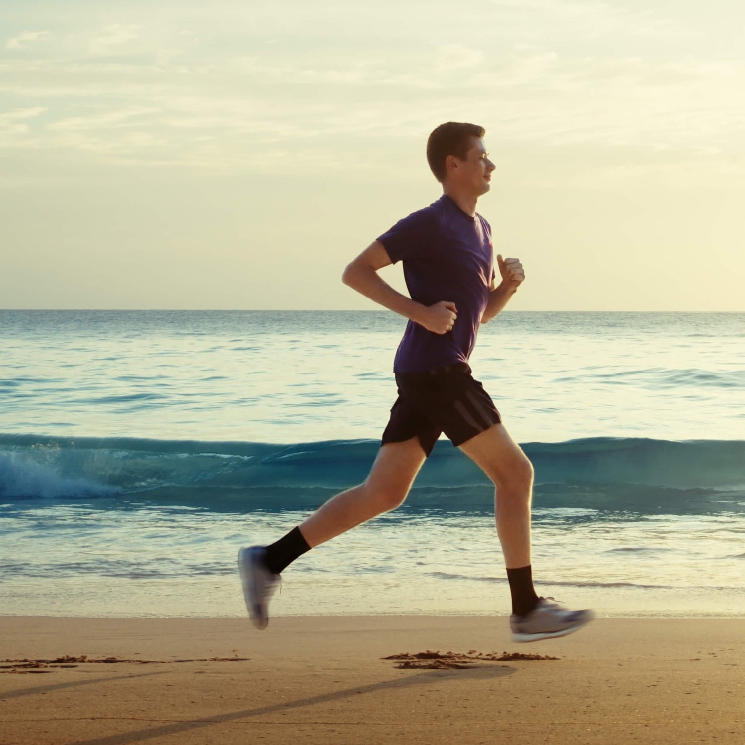 Man running on beach next to the ocean