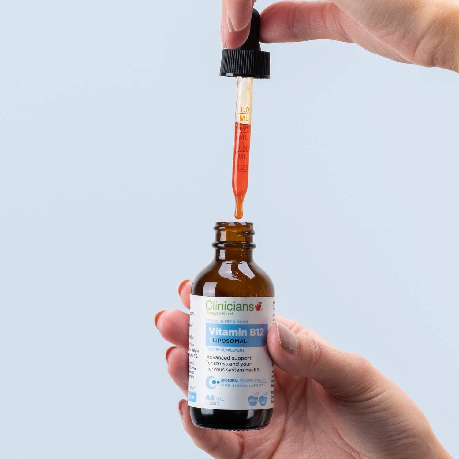 Hand holding liquid dropper over product