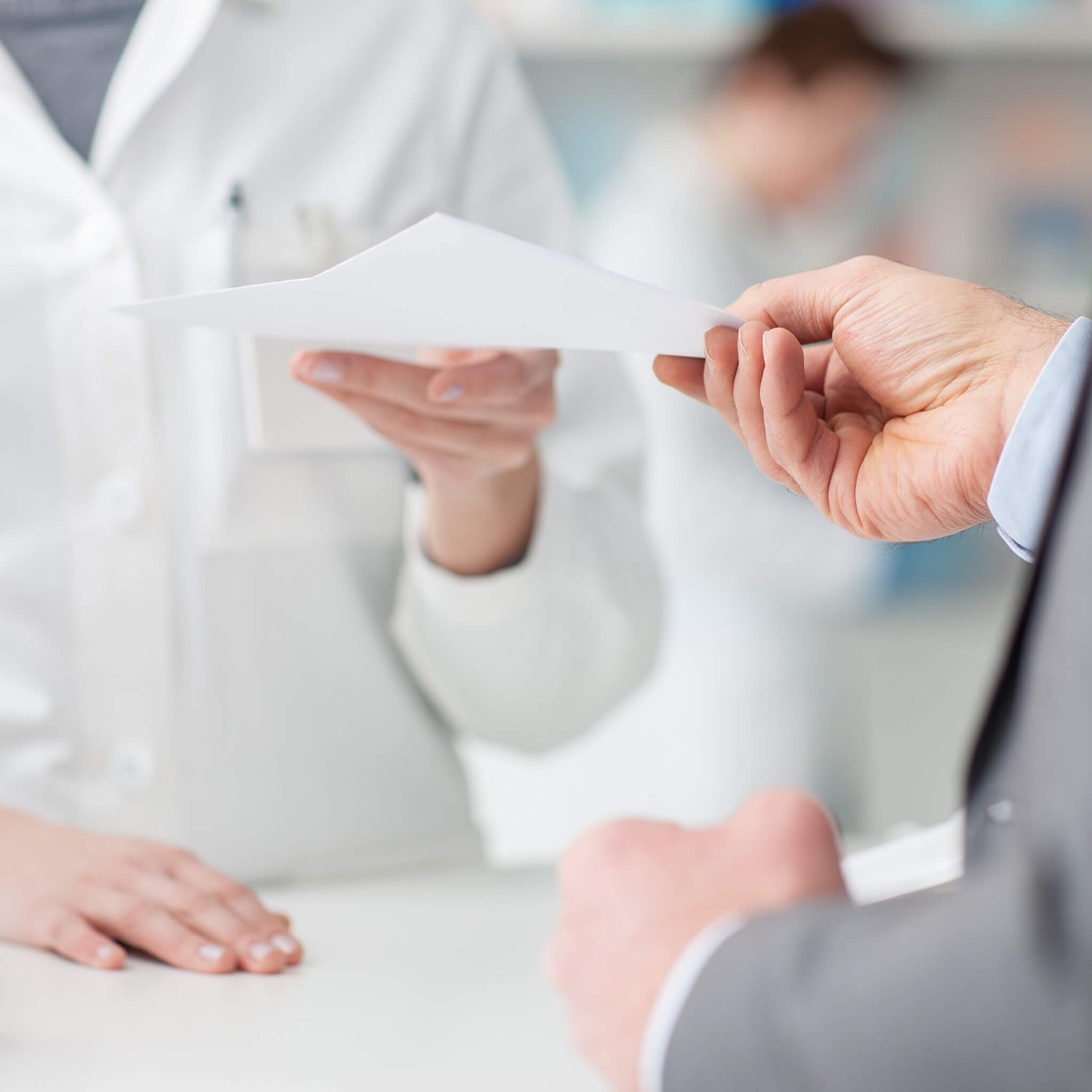 Patient handing a prescription to a pharmacist
