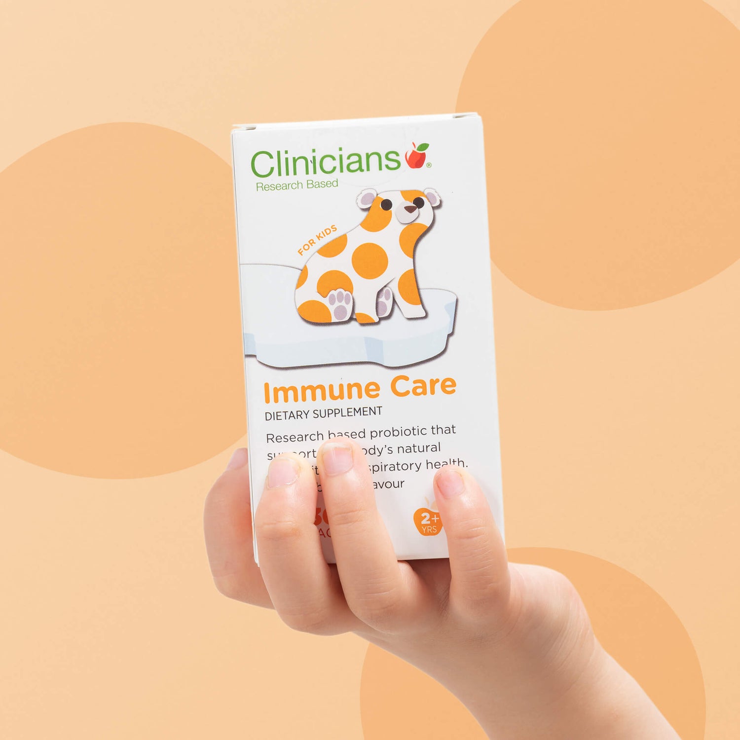 Child's hand holding a box of Clinicians Immune Care